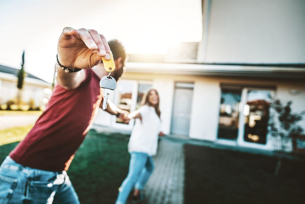 happy-young-couple-holding-home-keys-after-buying