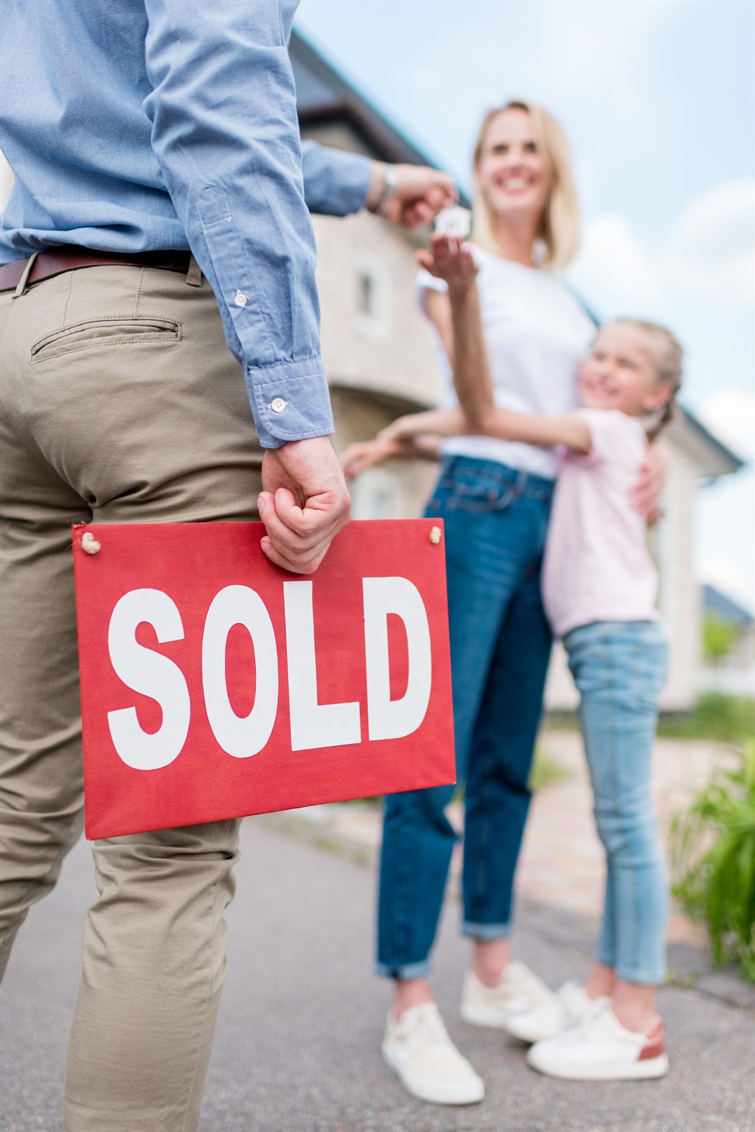 cropped-image-of-realtor-with-sold-sign-giving-key