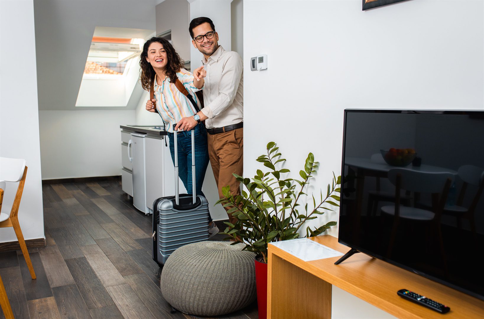 smiling-couple-with-suitcase-arriving-in-hotel