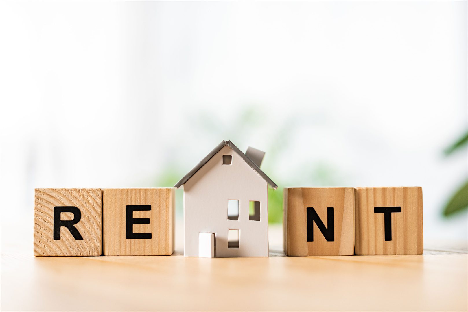 house-model-near-wooden-cubes-with-rent-lettering