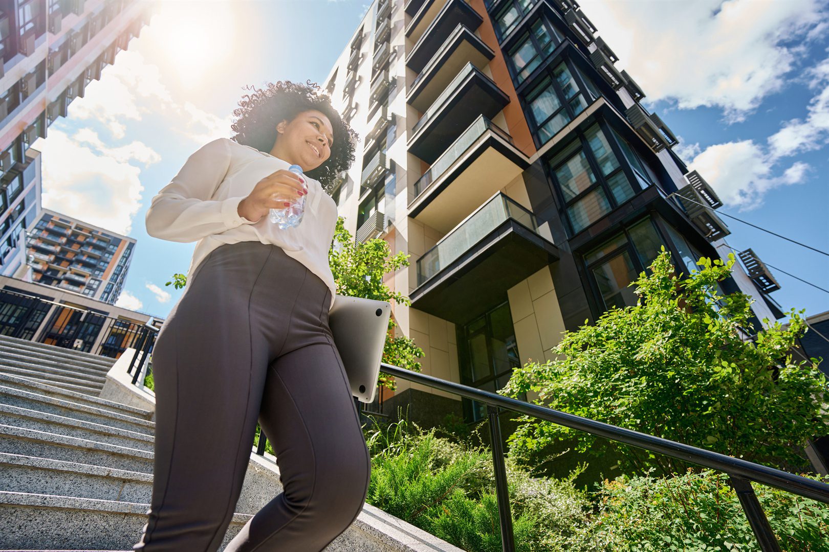 smiling-curly-woman-walking-down-the-stairs